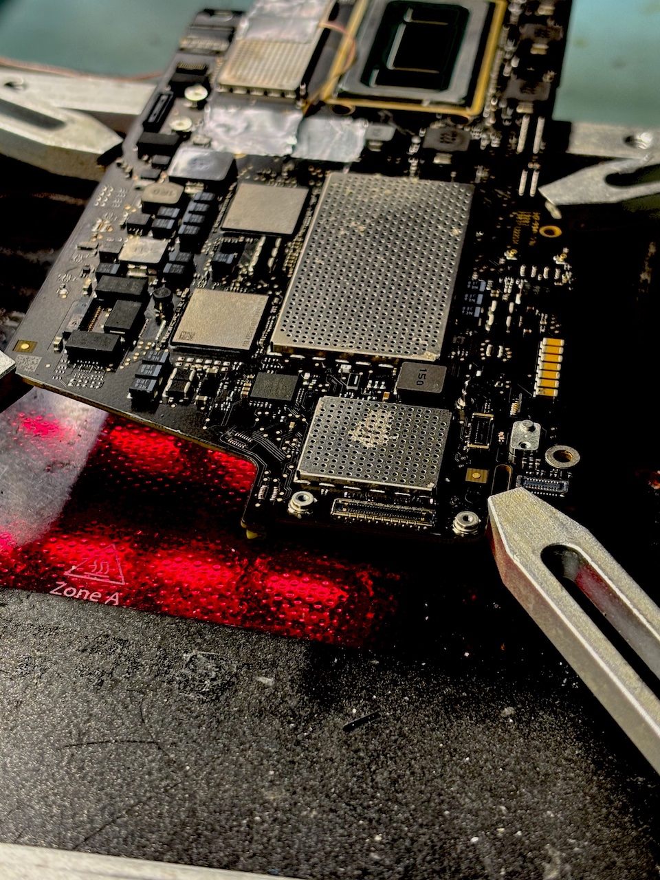 Płyta główna MacBook na stacji BGA z czujnikiem temperatury podczas rozlutowywania NAND